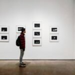 Man Standing Beside White Painted Wall