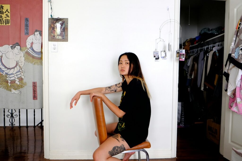 woman in black long sleeve shirt sitting on brown wooden chair